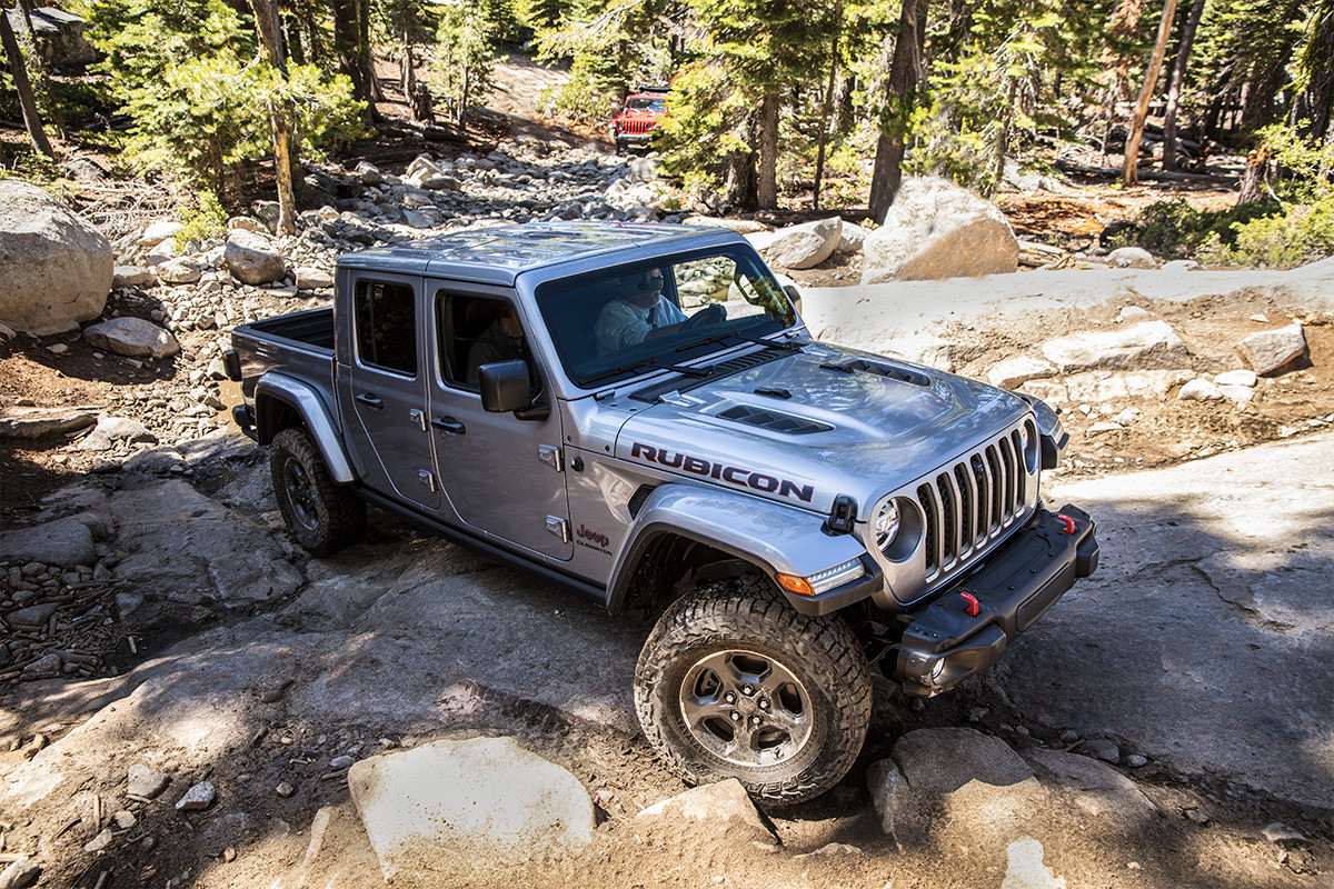 A light grey 2022 Jeep Gladiator parked on rocky terrain.