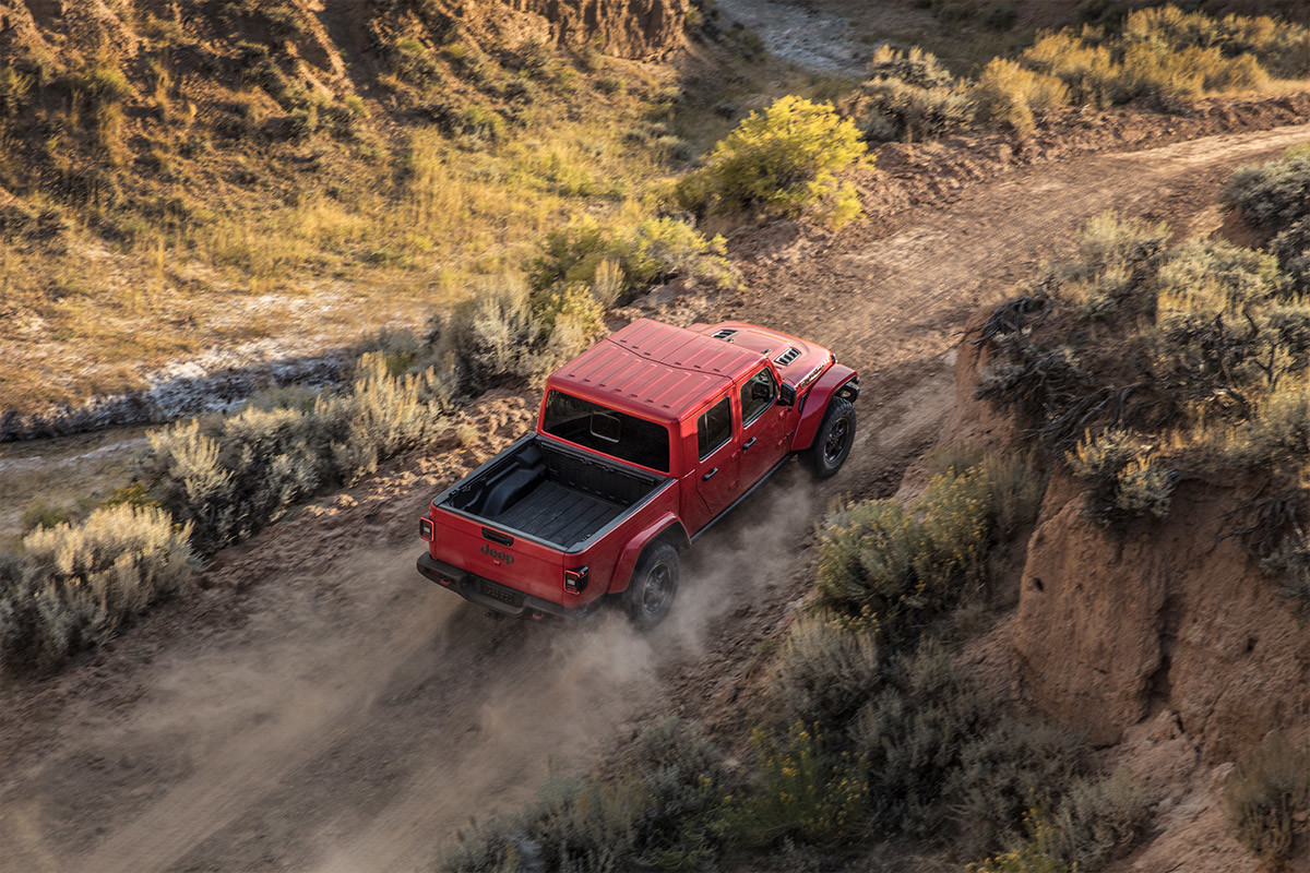 Bird's eye view of a red 2022 Jeep Gladiator driving through a field.