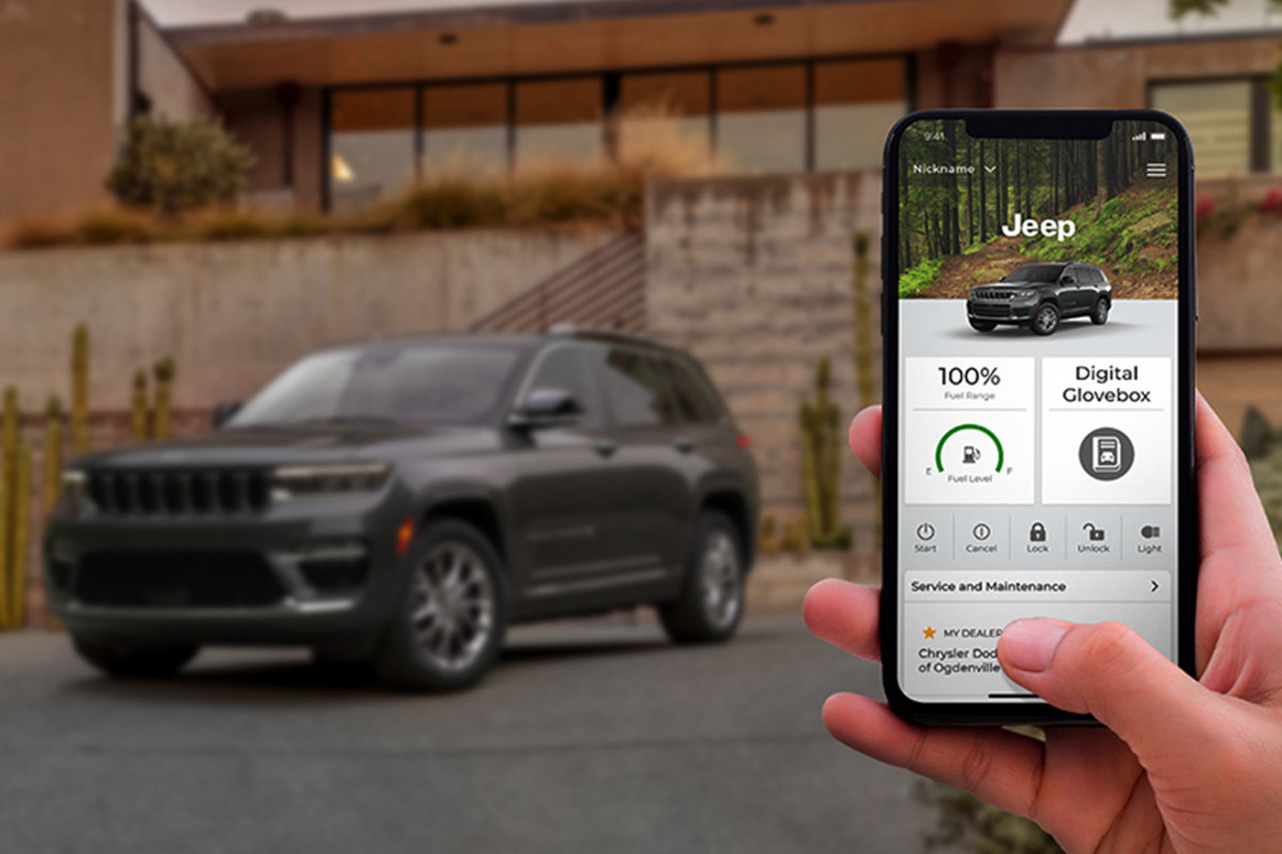Personne utilisant l’application Jeep Connect sur son téléphone intelligent. Jeep Grand Cherokee 2022 garé à l’arrière-plan devant un bâtiment.