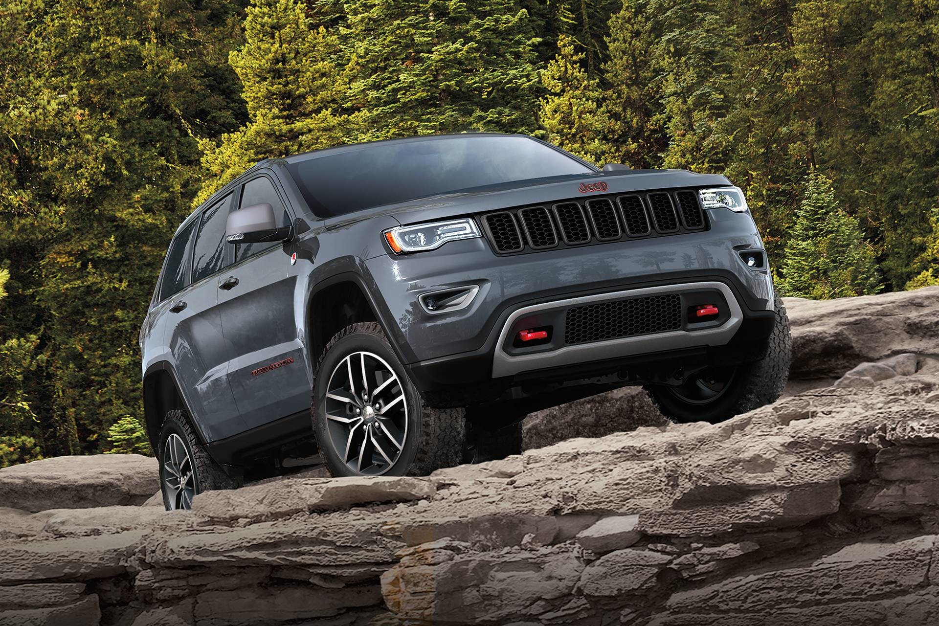 VUS Jeep Grand Cherokee 2018 – vue de côté hors route sur des rochers, illustré en rouge