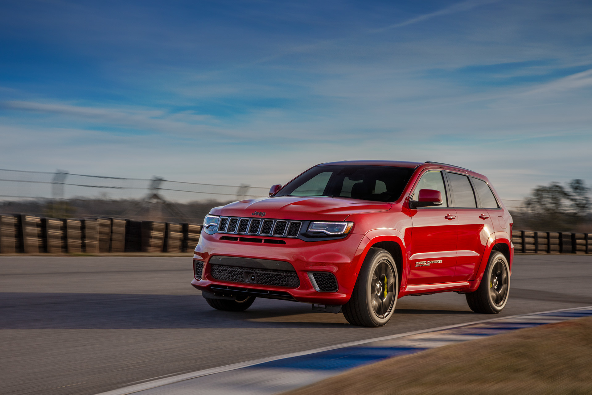 Un Jeep Grand Cherokee 2018 rouge roule à vive allure dans les rues