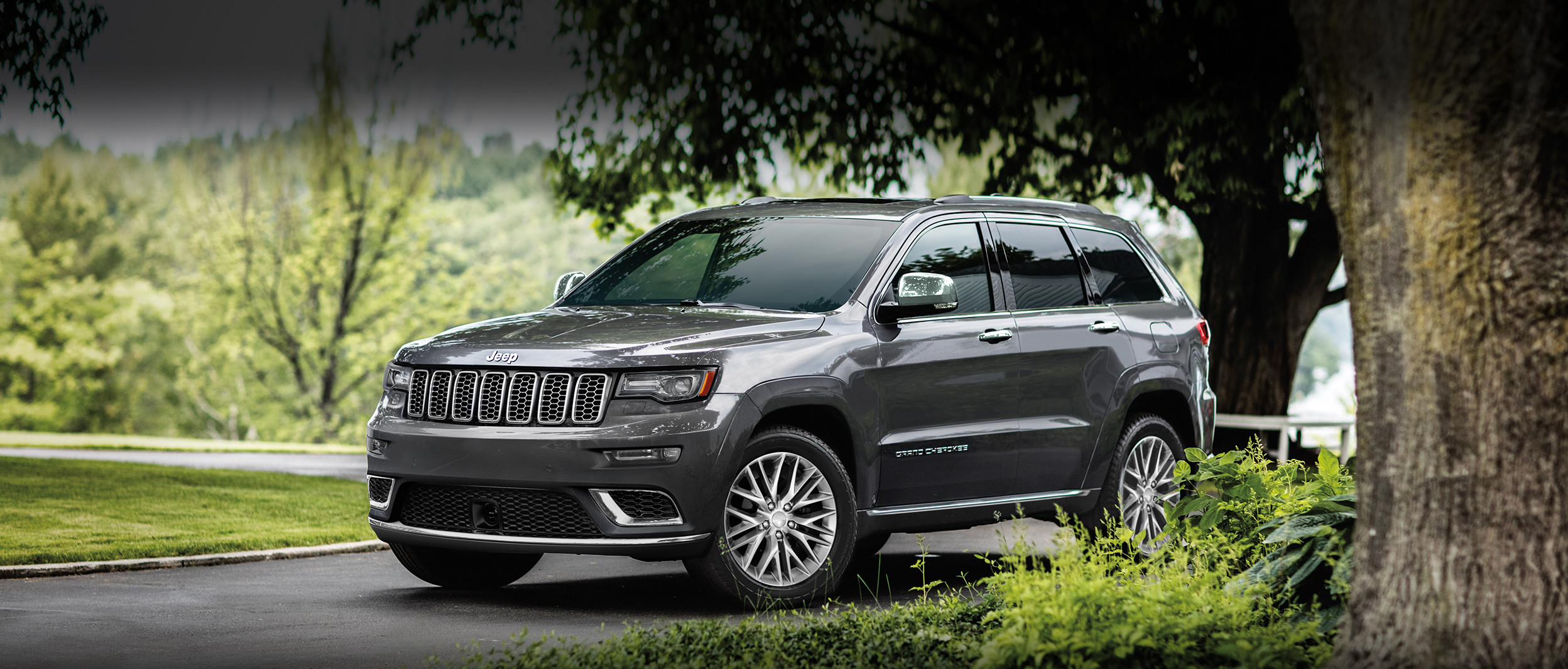 Grey 2018 Jeep Grand Cherokee Parked on the Road by the Hills