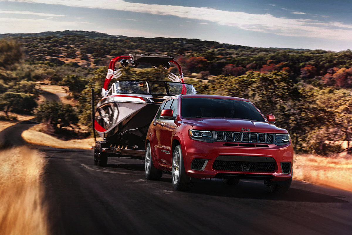 Jeep Grand Cherokee 2019 illustré en rouge, remorquant un bateau
