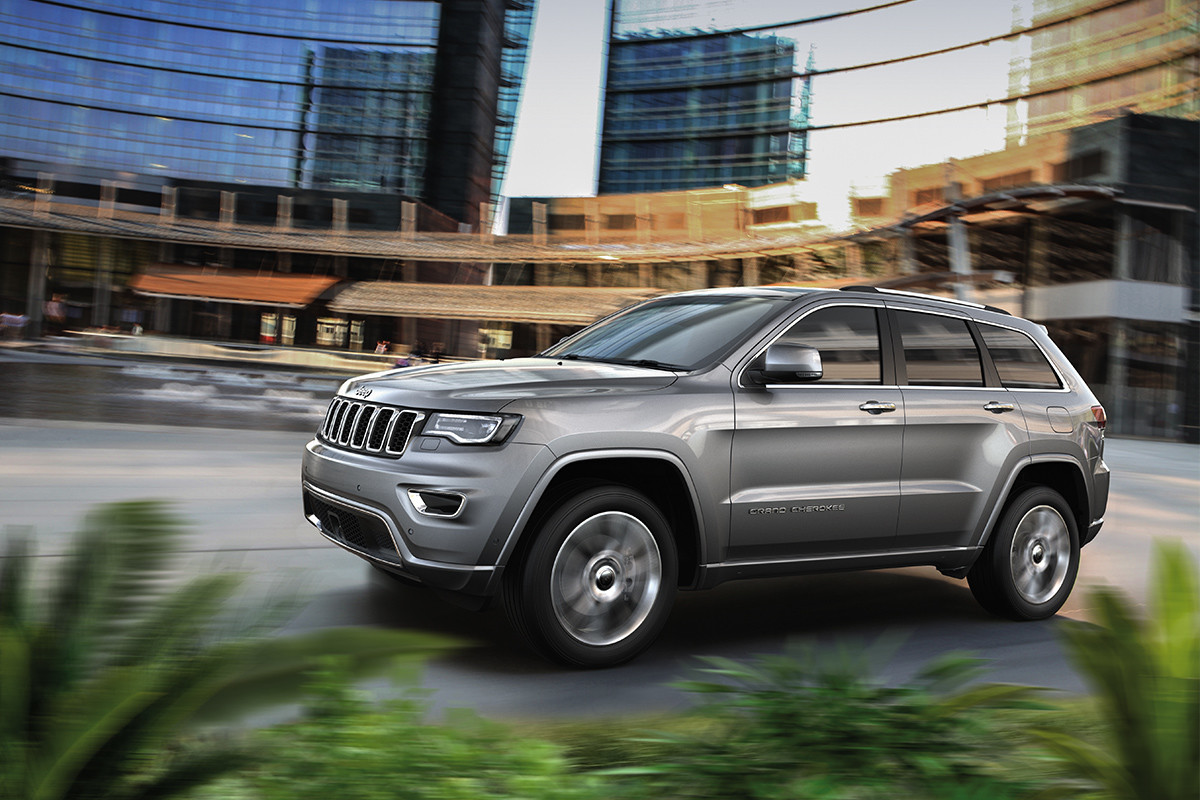 Jeep Grand Cherokee 2019 de couleur argent, vu de côté roulant en ville