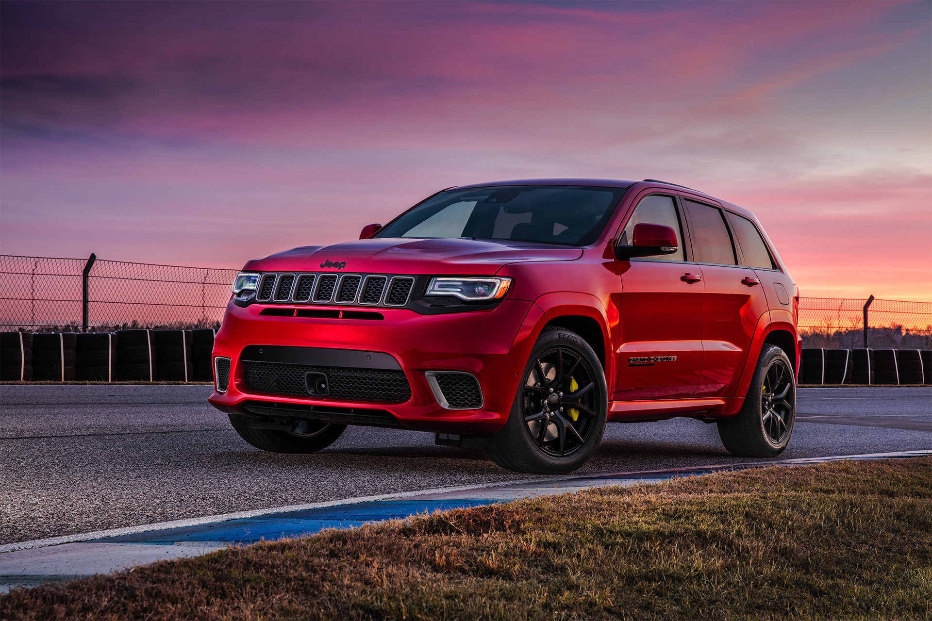 Jeep Grand Cherokee 2019 illustré en rouge stationné sur une piste de course