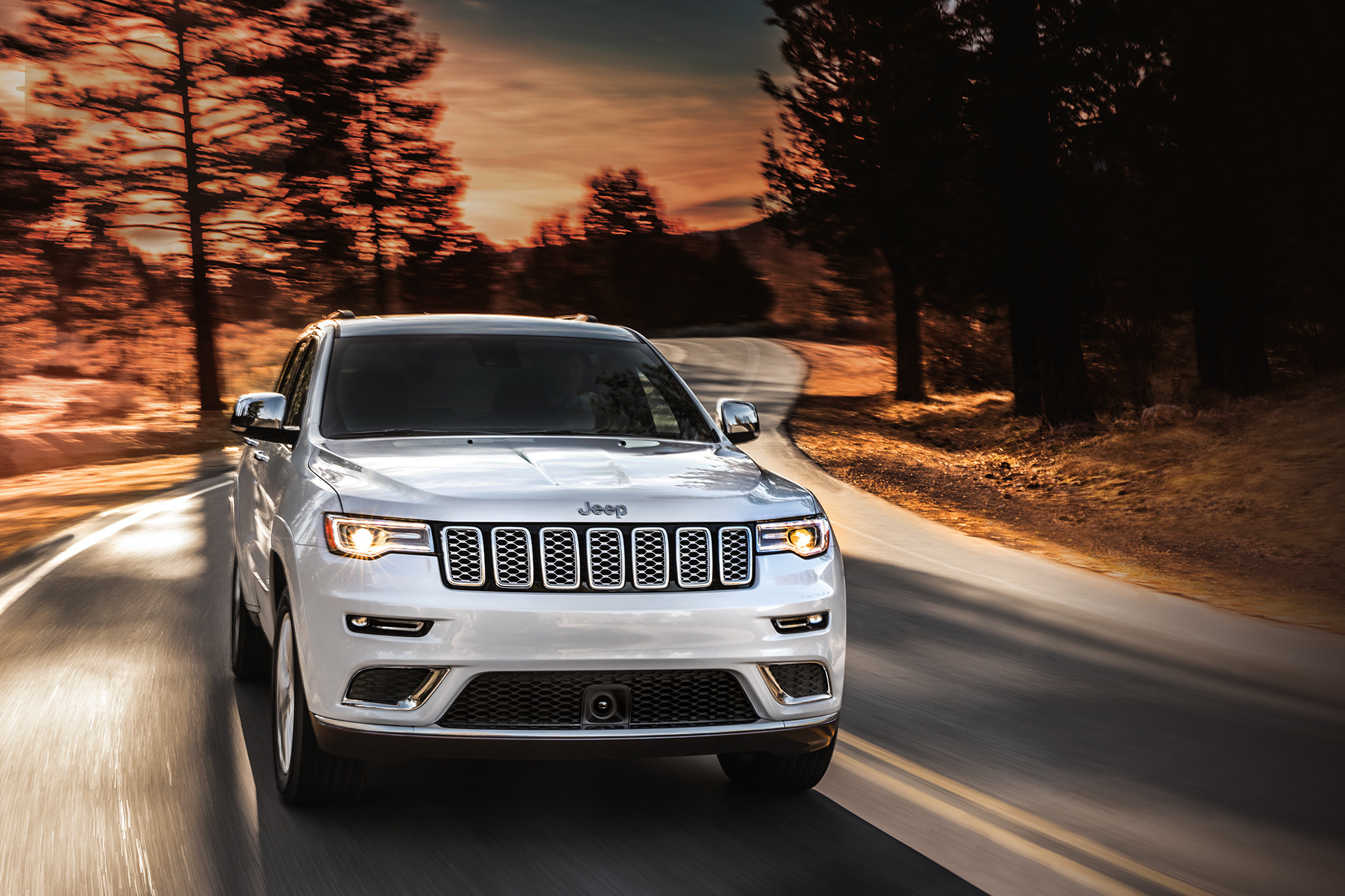 Jeep Grand Cherokee 2019 illustré en blanc, roulant sur une route
