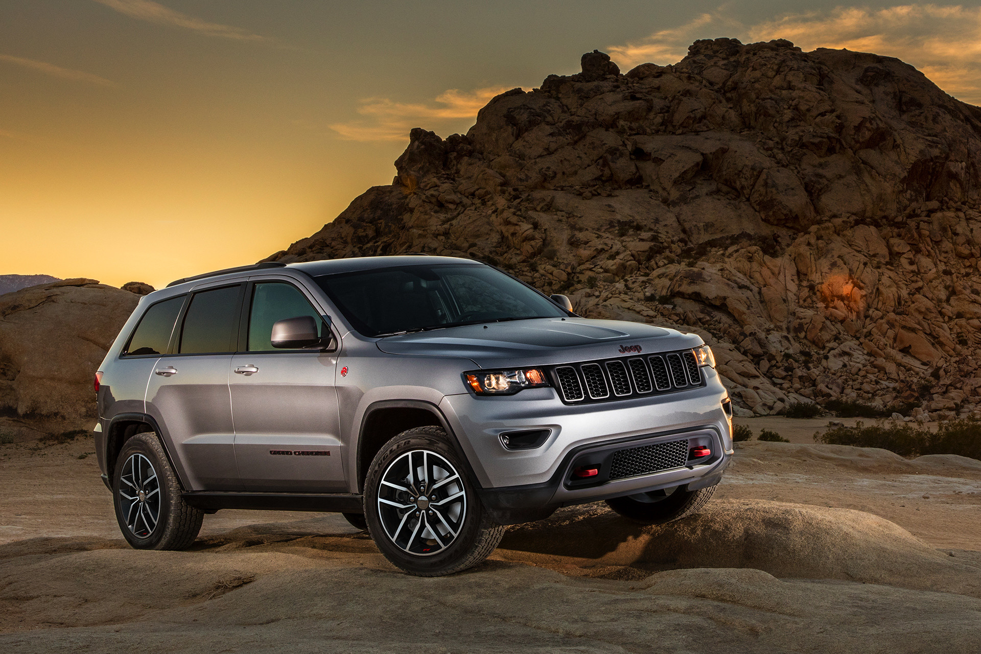 Jeep Grand Cherokee 2019 de couleur argent roulant sur de grosses roches