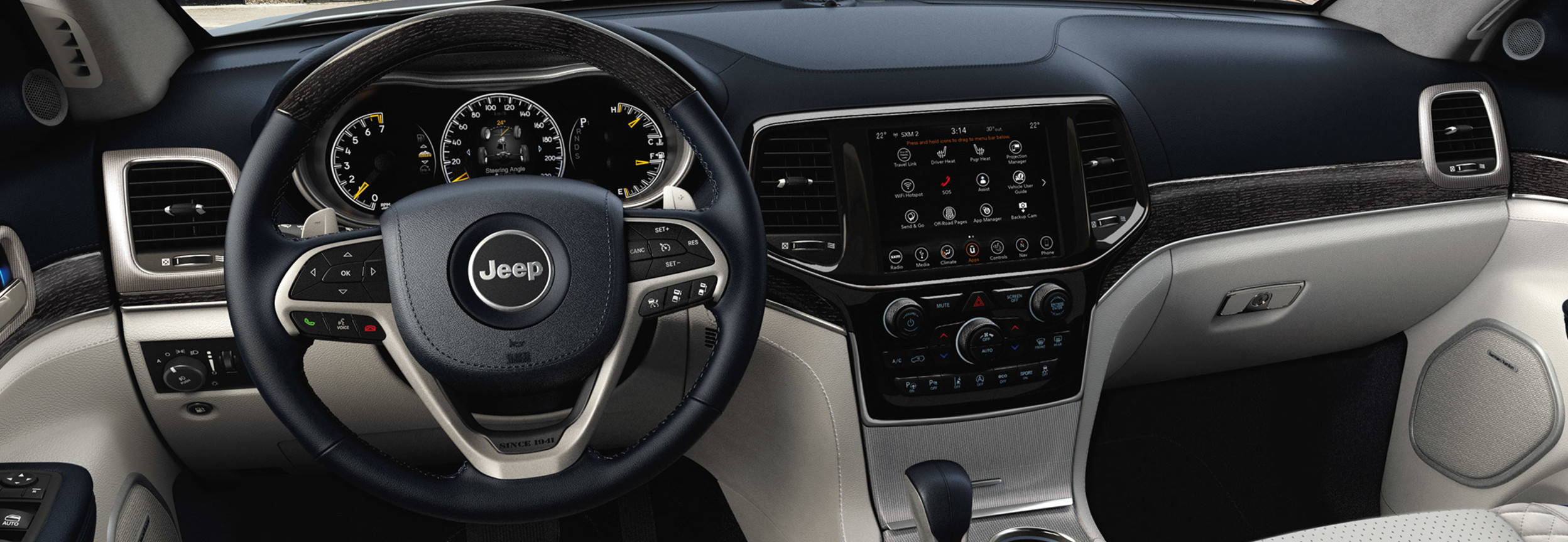 Interior view of a Jeep Grand Cherokee including the steering wheel and entertainment system