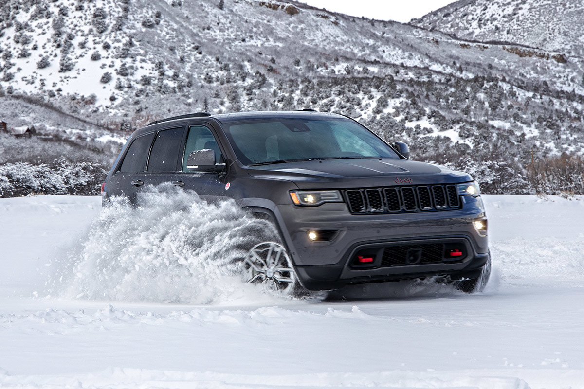 Front view of the 2020 Jeep Grand Cherokee in grey parked in snow in the mountains