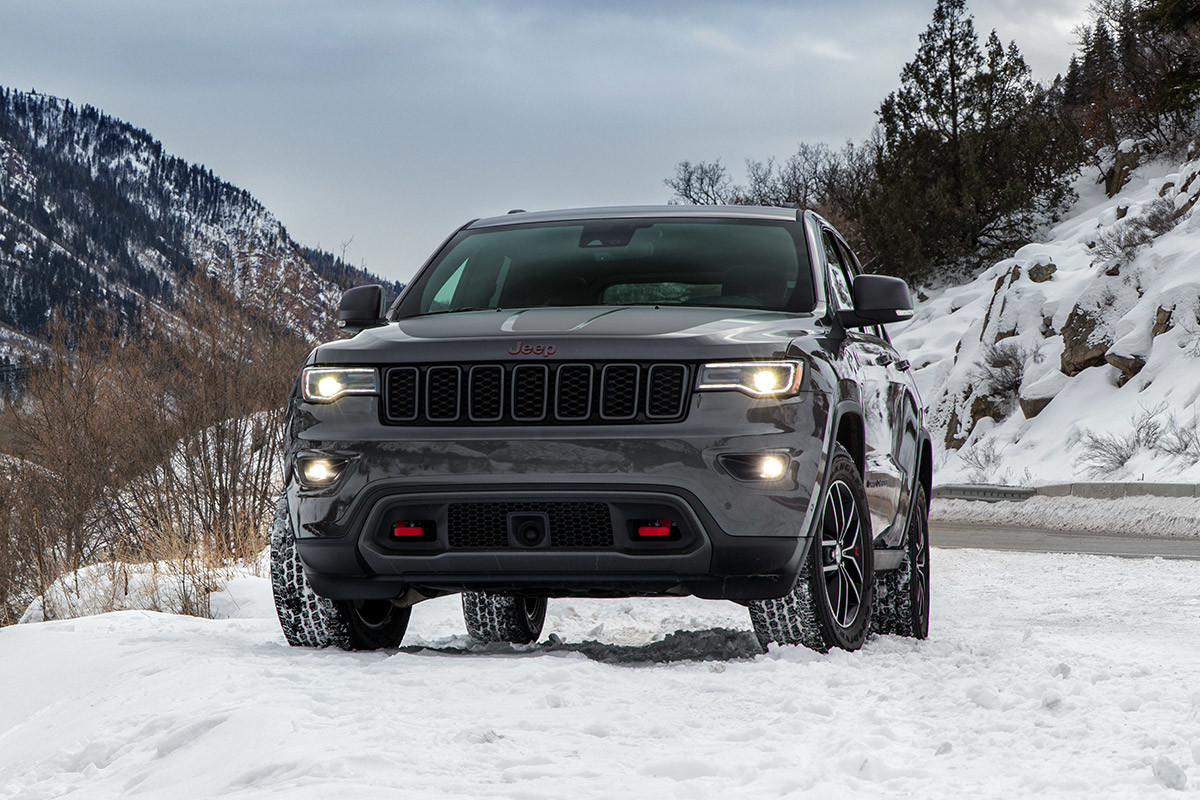 Front view of the 2020 Jeep Grand Cherokee in grey parked in the mountains