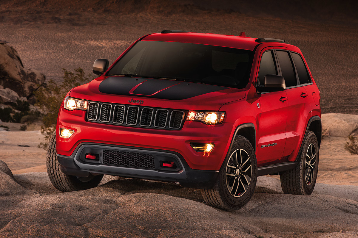 Red 2020 Jeep Grand Cherokee parked on an open sandy plain.