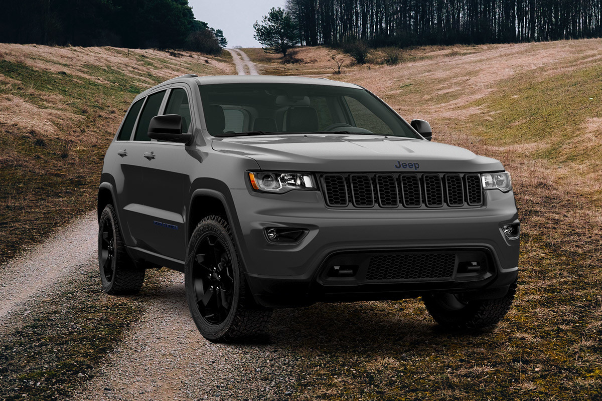 The 2020 Jeep Grand Cherokee Upland in granite crystal metallic colour parked on a dirt road in a mountain