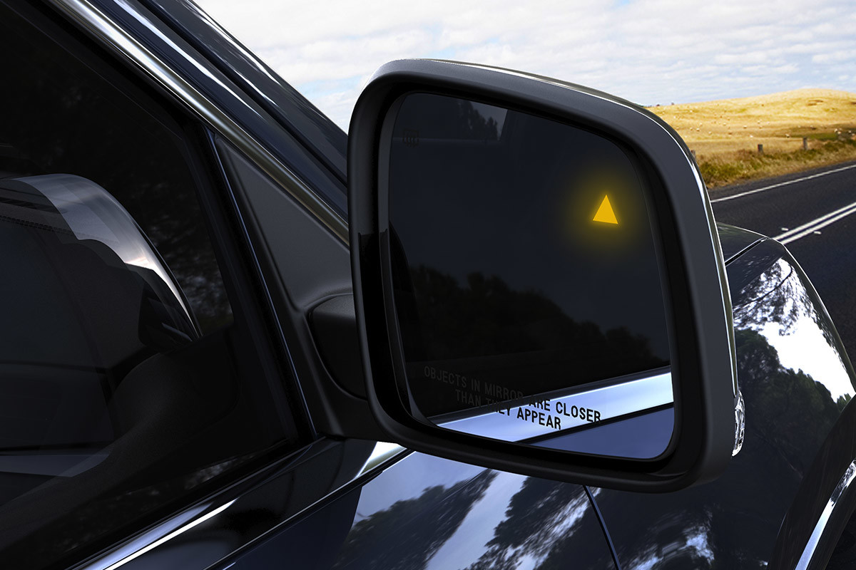 Right side mirror of a black 2020 Jeep Grand Cherokee.