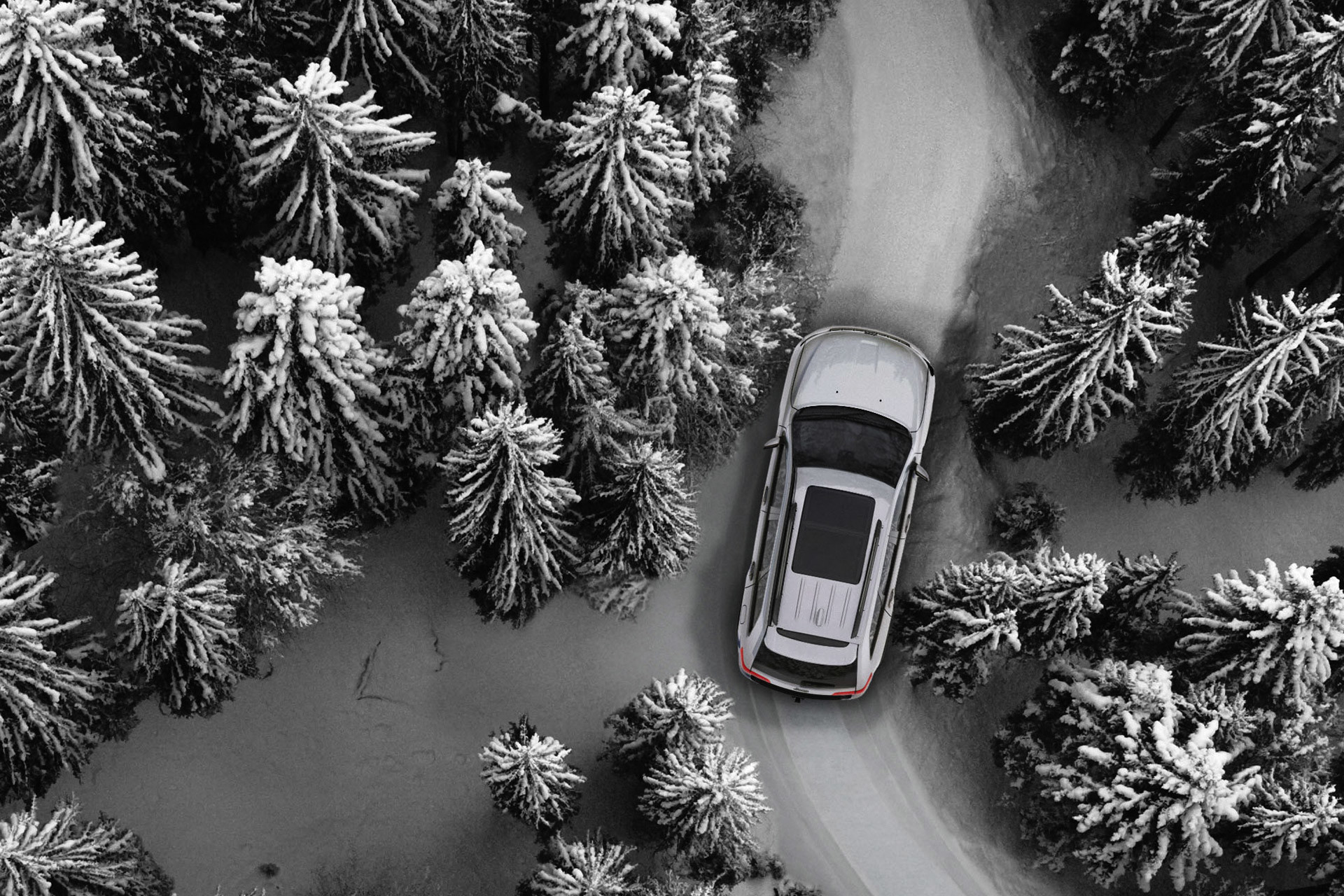 Bird's eye view of the 2020 Jeep Grand Cherokee in white driving through a snowcovered forest