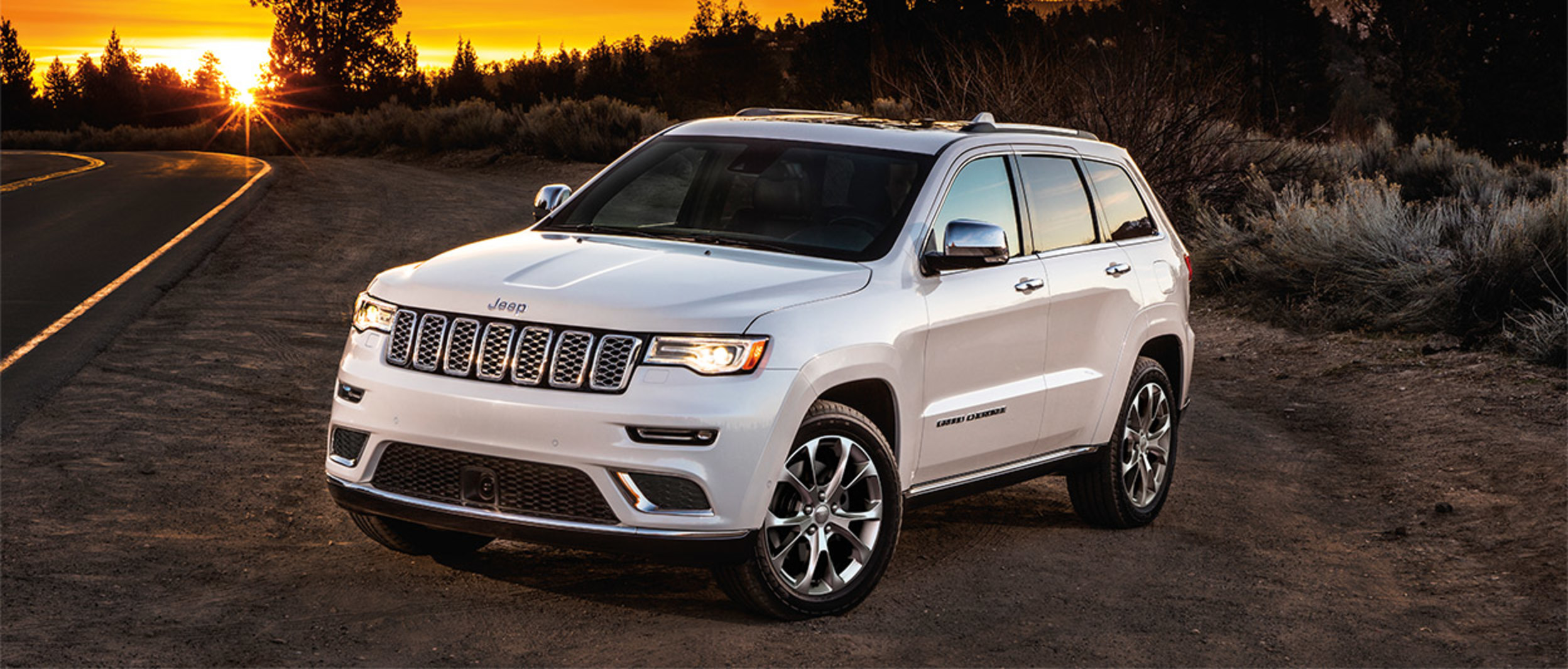 A white 2020 Jeep Grand Cherokee parked on the side of the road