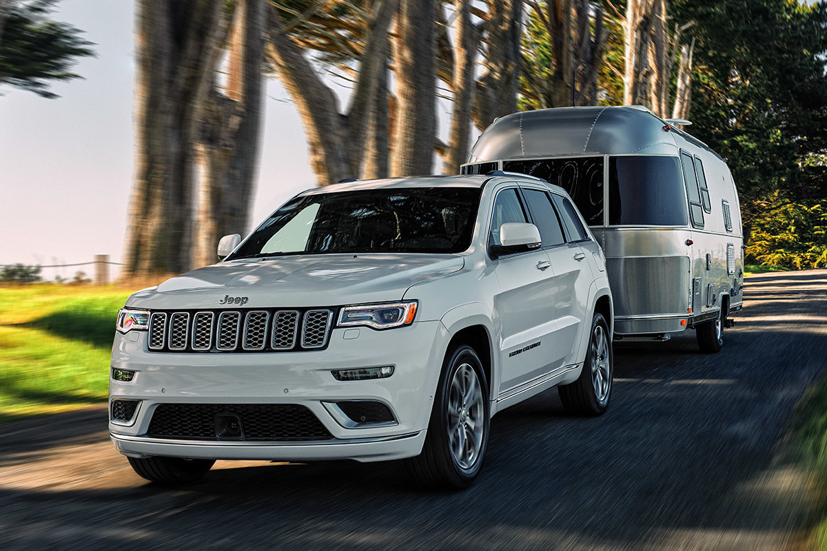 Jeep Grand Cherokee 2021 blanc roulant dans une rue urbaine