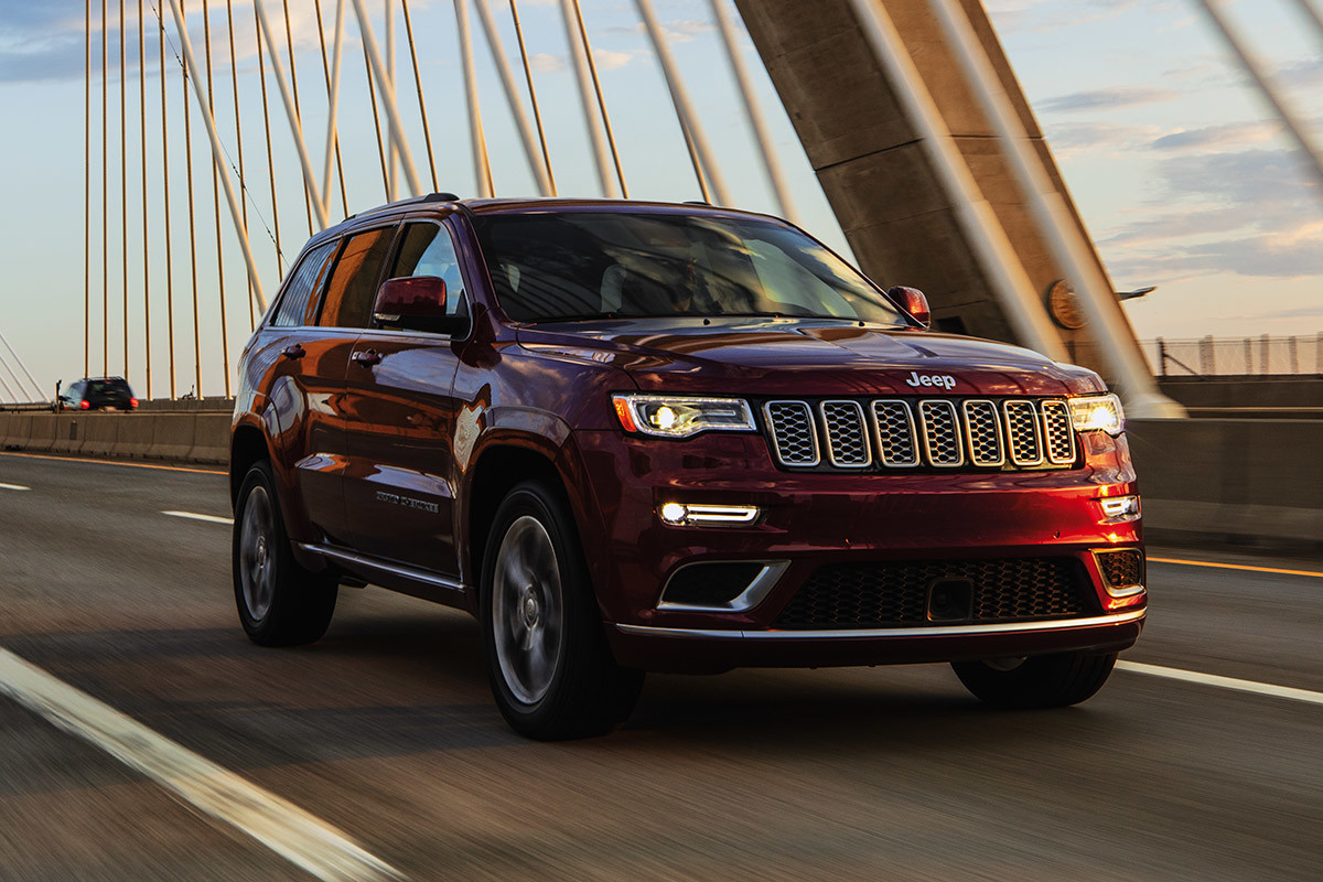 Red 2021 Jeep Grand Cherokee driving across a bridge.