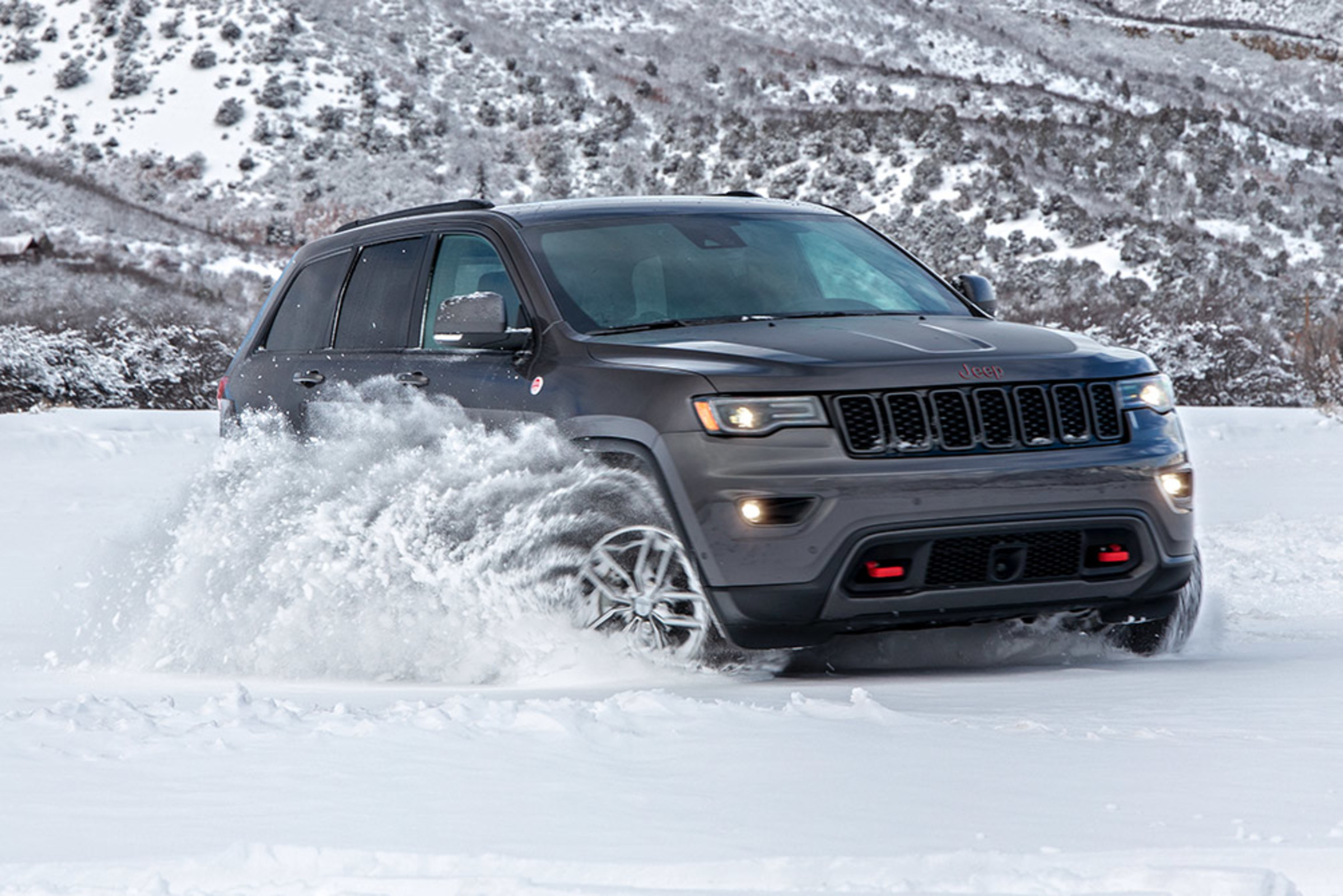 Front quarter view of a grey 2021 Grand Cherokee being driven in the snow