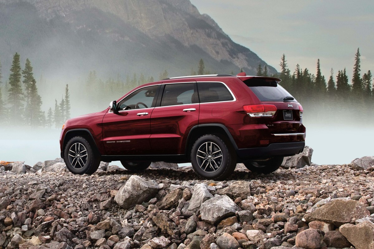 Grand Cherokee WK Limited 2022 couleur rouge rouge velours nacré, garé près du lac avec des montagnes au loin.