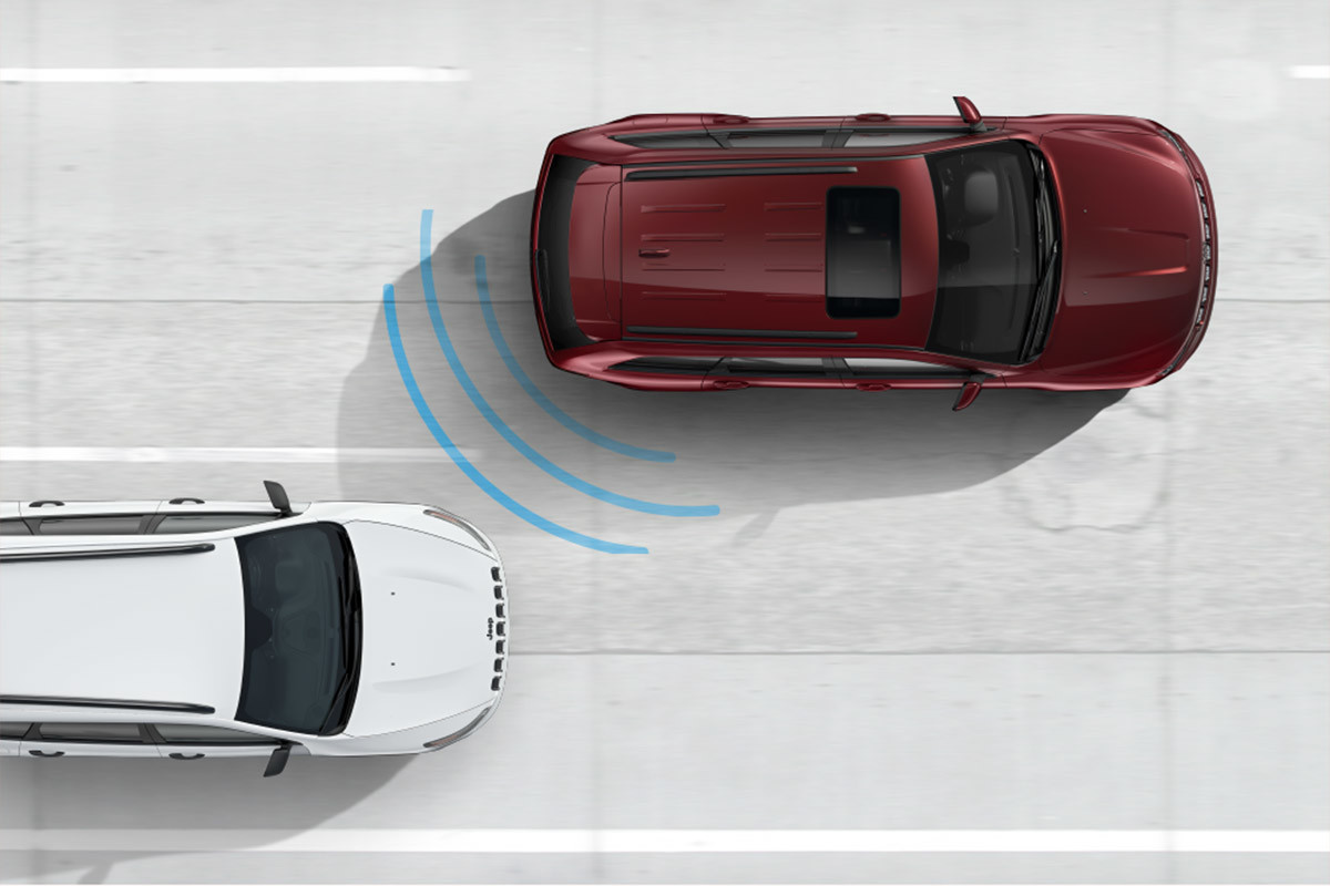 Vue de dessus du Grand Cherokee WK derrière un autre véhicule montrant la fonction de surveillance des angles morts.