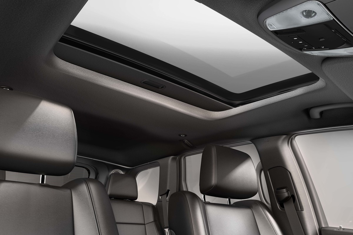 Side view of the cabin showing the front and rear seats and the sunroof.