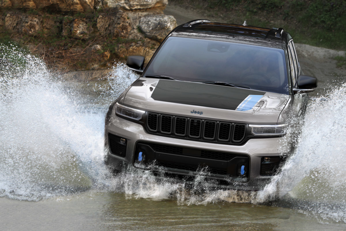 Un tout nouveau Jeep Grand Cherokee 4xe 2022 gris roulant dans l’eau.