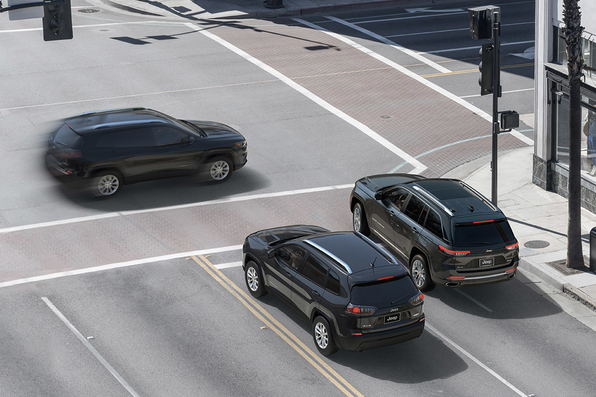 Three vehicles at an intersection showing off the All-New 2022 Jeep Grand Cherokee 4xe feature, Intersection Collision Assist.