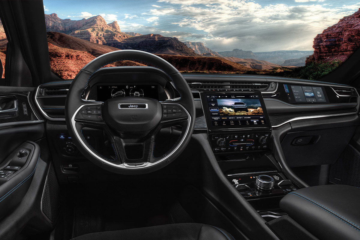 Vue du siège du conducteur à bord du tout nouveau Jeep Grand Cherokee 4xe 2022 avec une montagne en arrière-plan.