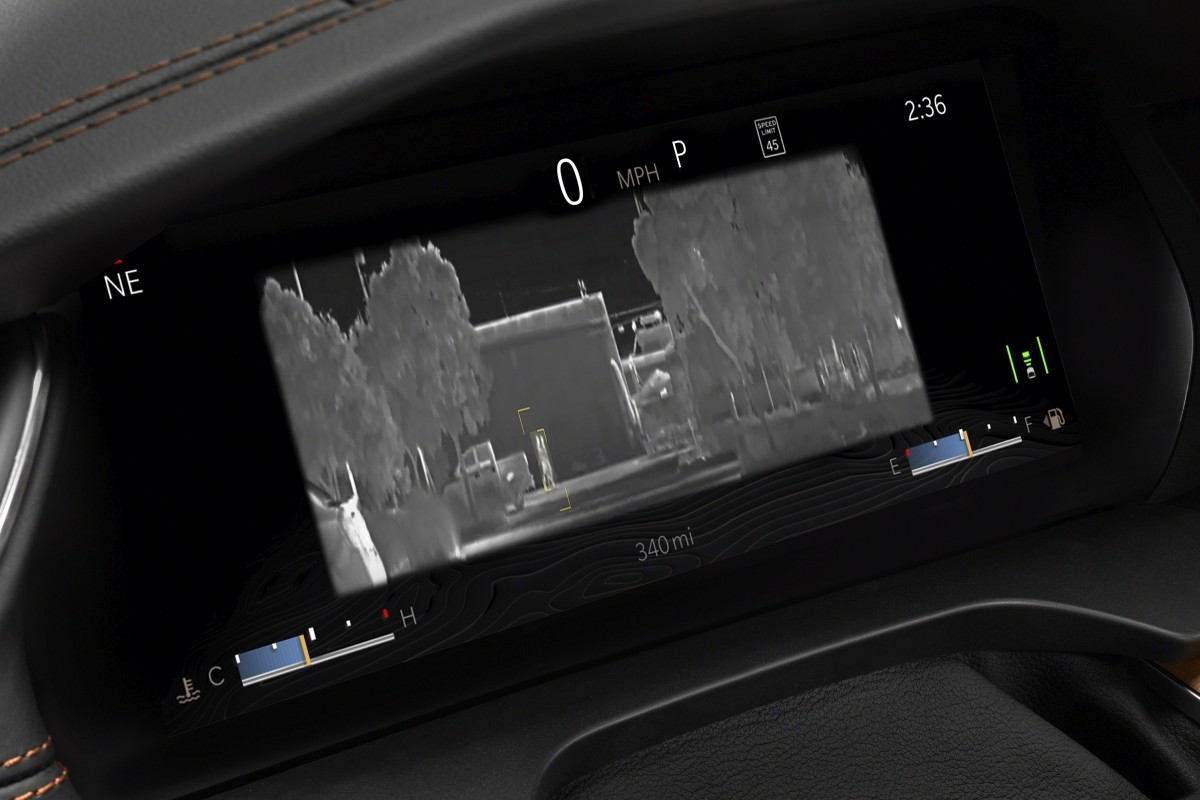 Vue de l'écran intégré à la console du Jeep Grand Cherokee L 2021 montrant la caméra à vision nocturne, qui révèle des piétons sur la route.