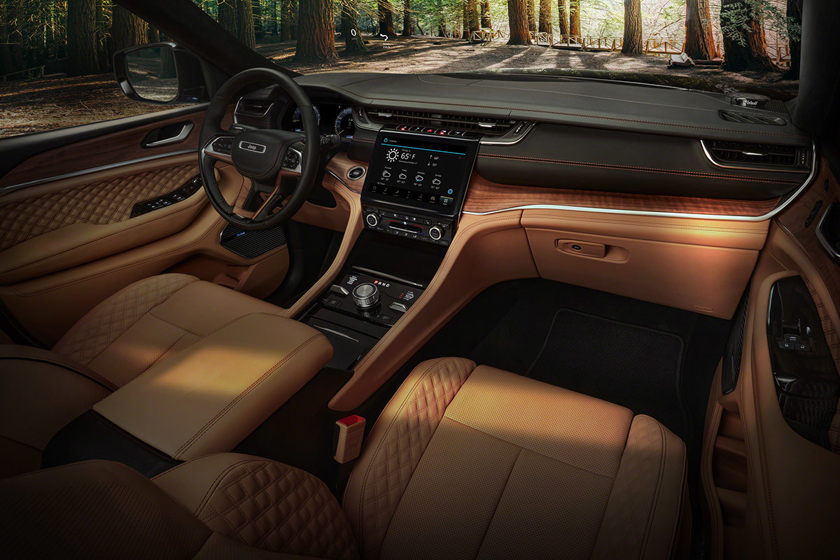 Vue en plongée des sièges avant couleur Tupelo, en cuir Palermo matelassé et des garnitures intérieures en bois ciré dans la cabine raffinée du tout nouveau Grand Cherokee L Summit Reserve 2021.