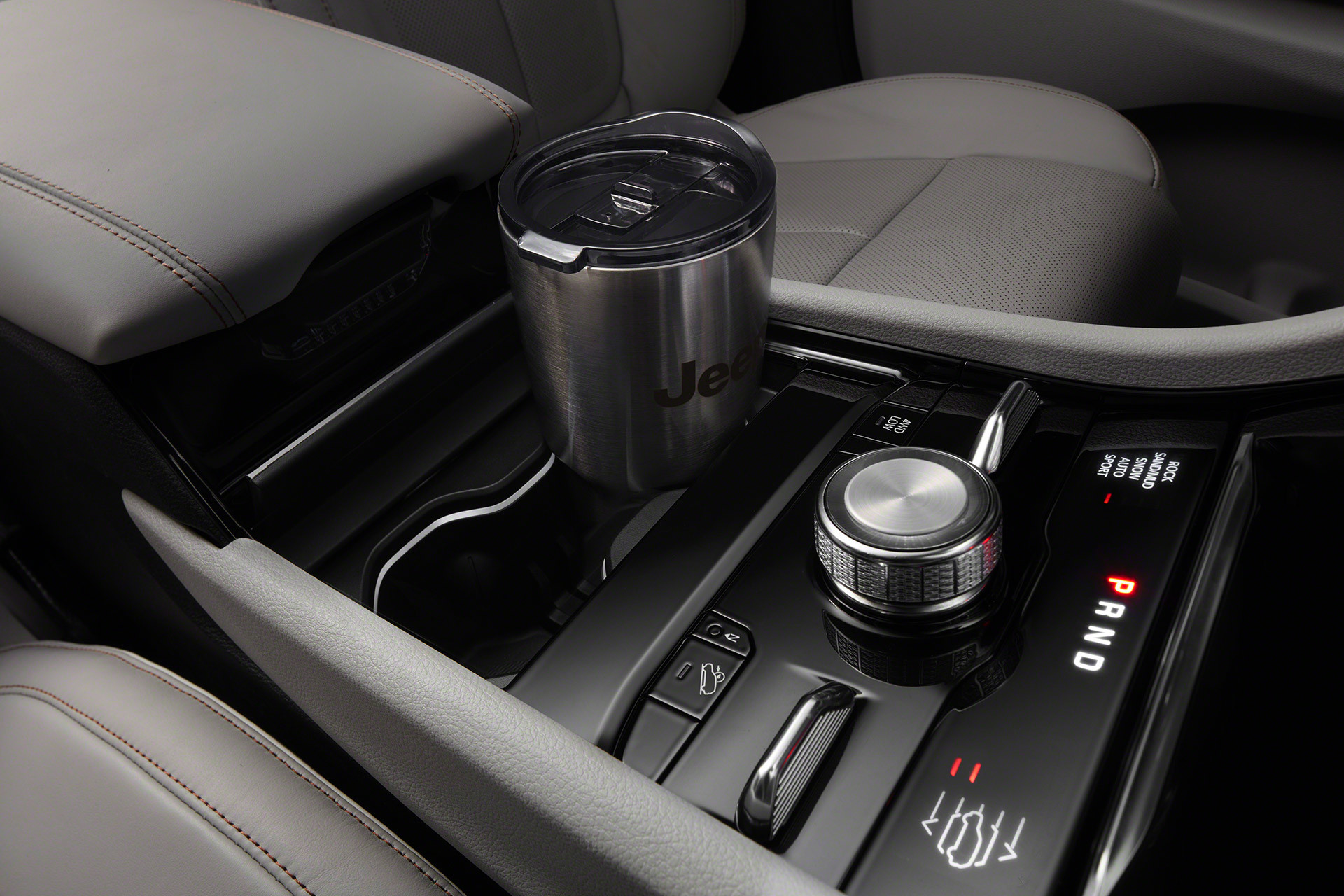 Gros plan d’une tasse de café en aluminium dans un porte-gobelets intégré à la console centrale pleine longueur du tout nouveau Grand Cherokee L 2021.