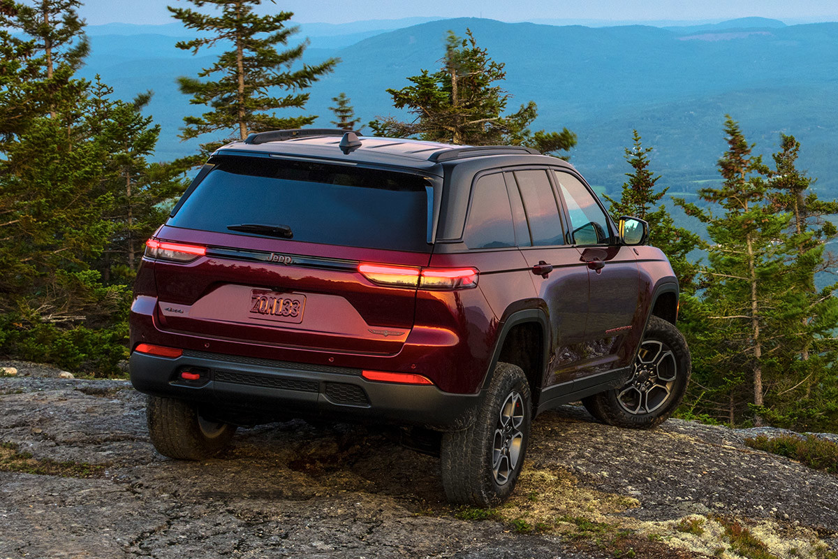 Un Jeep Grand Cherokee Trailhawk 2022 rouge stationné sur une colline