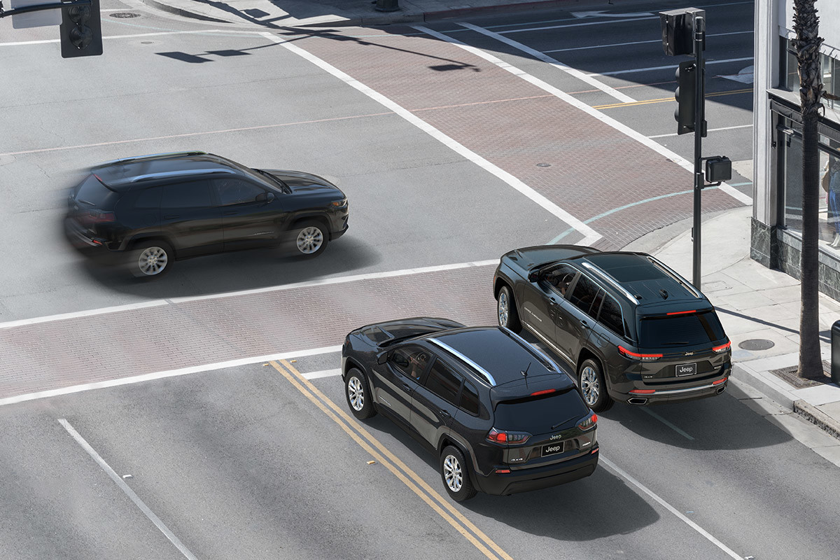 Le système de prévention des collisions dans les intersections du Jeep Grand Cherokee 2022 illustré par trois véhicules se trouvant à une intersection.