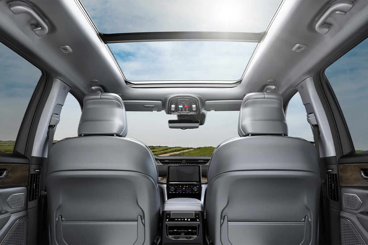 Back seat view of the Uconnect 5 system, with a view of the sunroof inside the 2022 Jeep Grand Cherokee