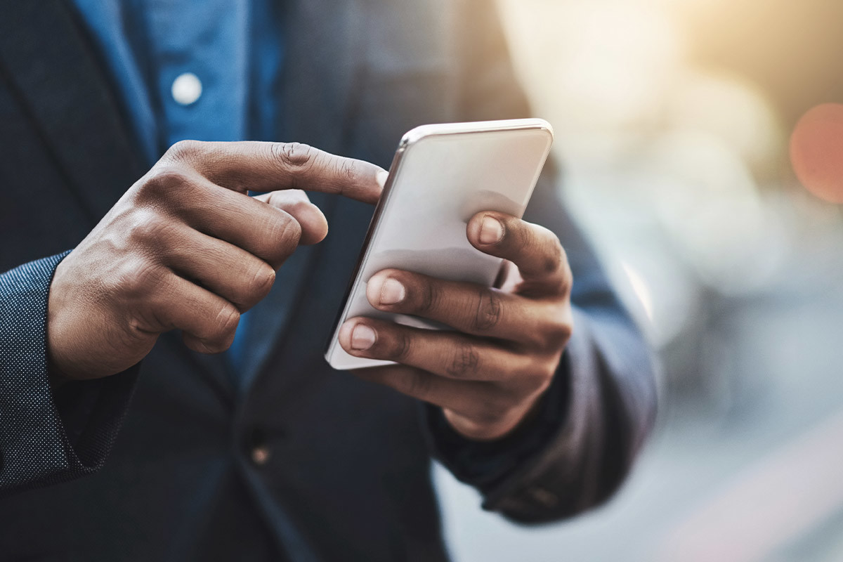 Close-up of a person's hand tapping the screen of a mobile device