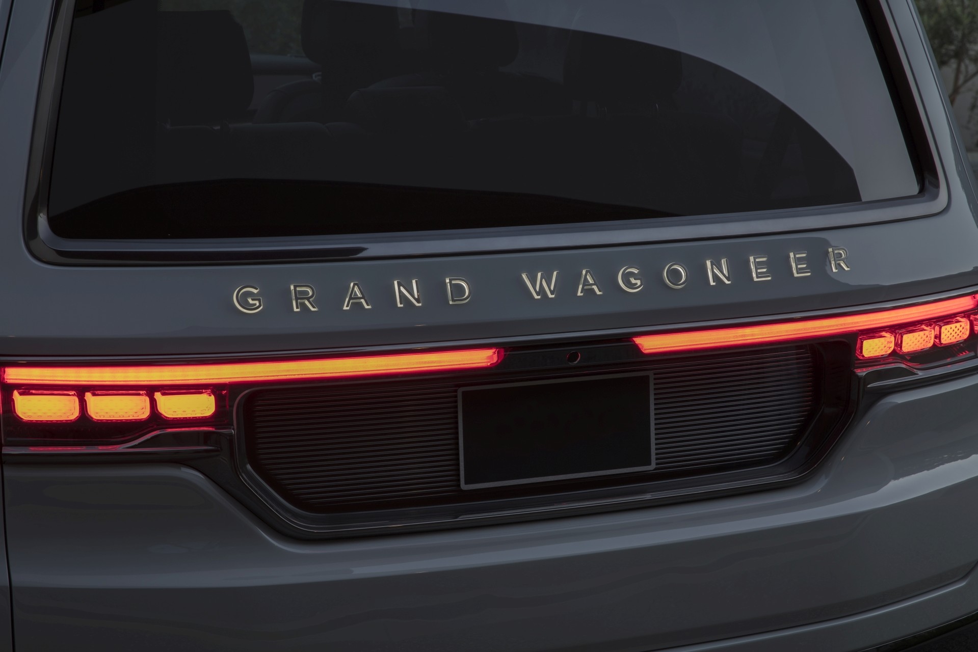 Gros plan du hayon du concept Grand Wagoneer, avec le nom éclairé et les feux d’arrêt allumés.