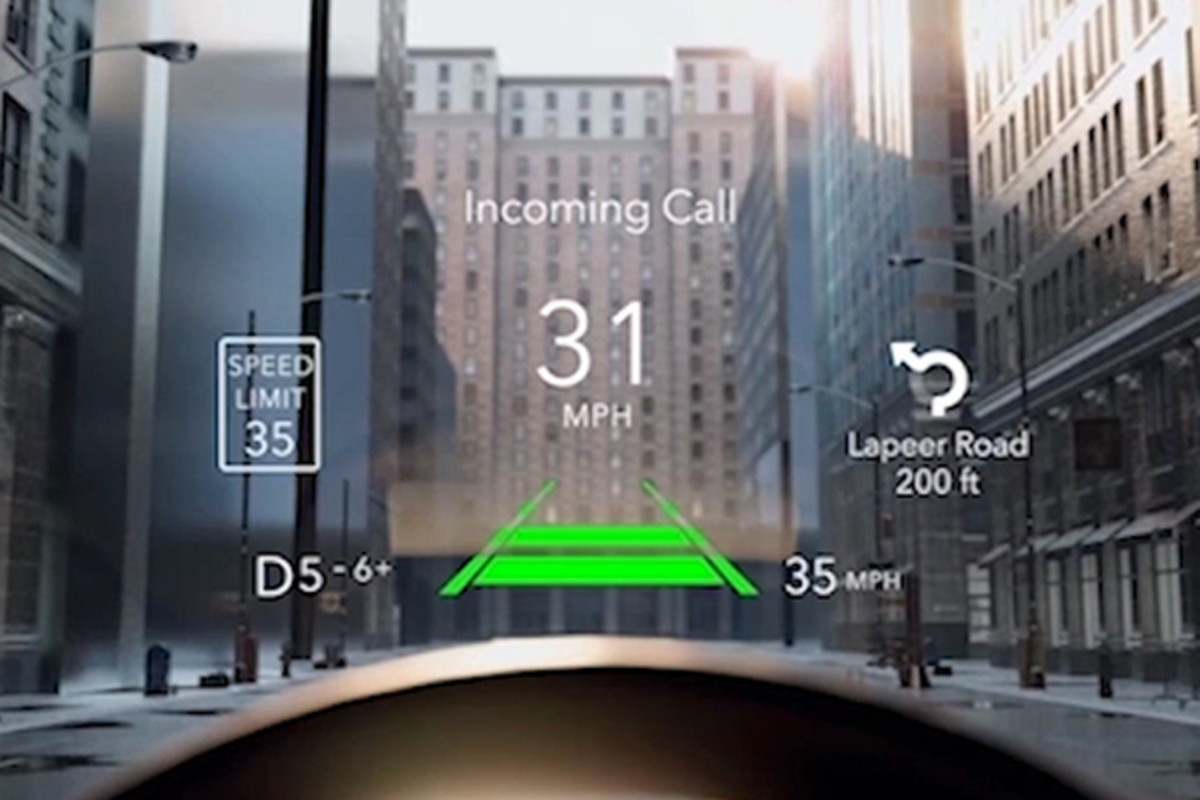 DRIVER SAFETY & SECURITY A close-up of the Heads Up Display that will soon be available as part of the safety systems for all Jeep vehicles. City buildings are visible through the windshield in the background.