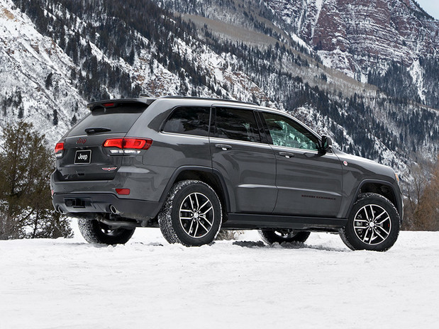 Vue arrière du Jeep Grand Cherokee 2020 en gris, stationné dans une clairière couverte de neige, sur une montage