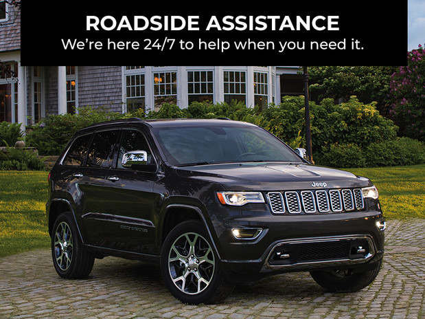 Roadside assistance. We’re here 24/7 to help when you need it. Dark grey Jeep® Cherokee, parked in front of a house.