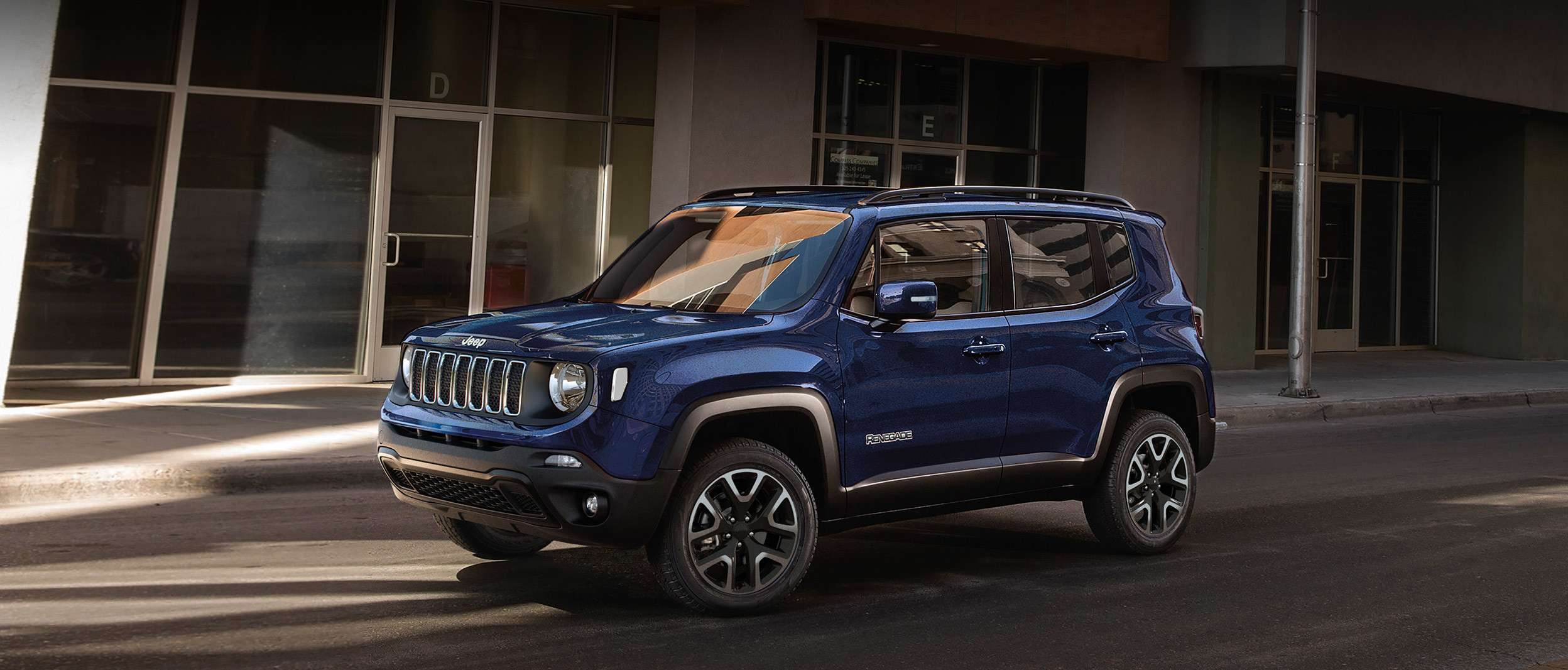 Jeep Renegade 2019 avec extérieur rouge garé devant une cascade.