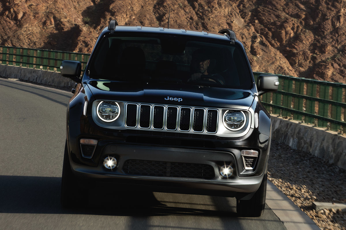 Front view of Jeep Renegade being driven on a road beside mountains