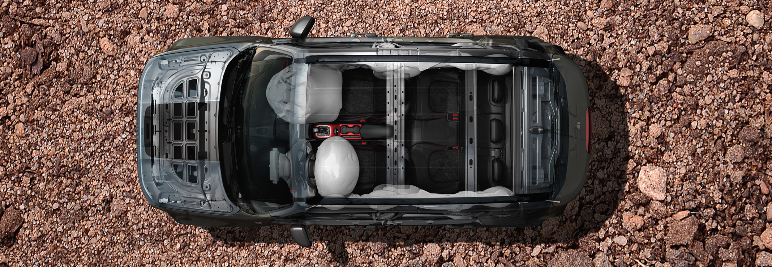 Vue aérienne d’un Jeep Renegade garé sur un paysage rocheux, avec l’infrastructure du véhicule visible, y compris les sacs gonflables.