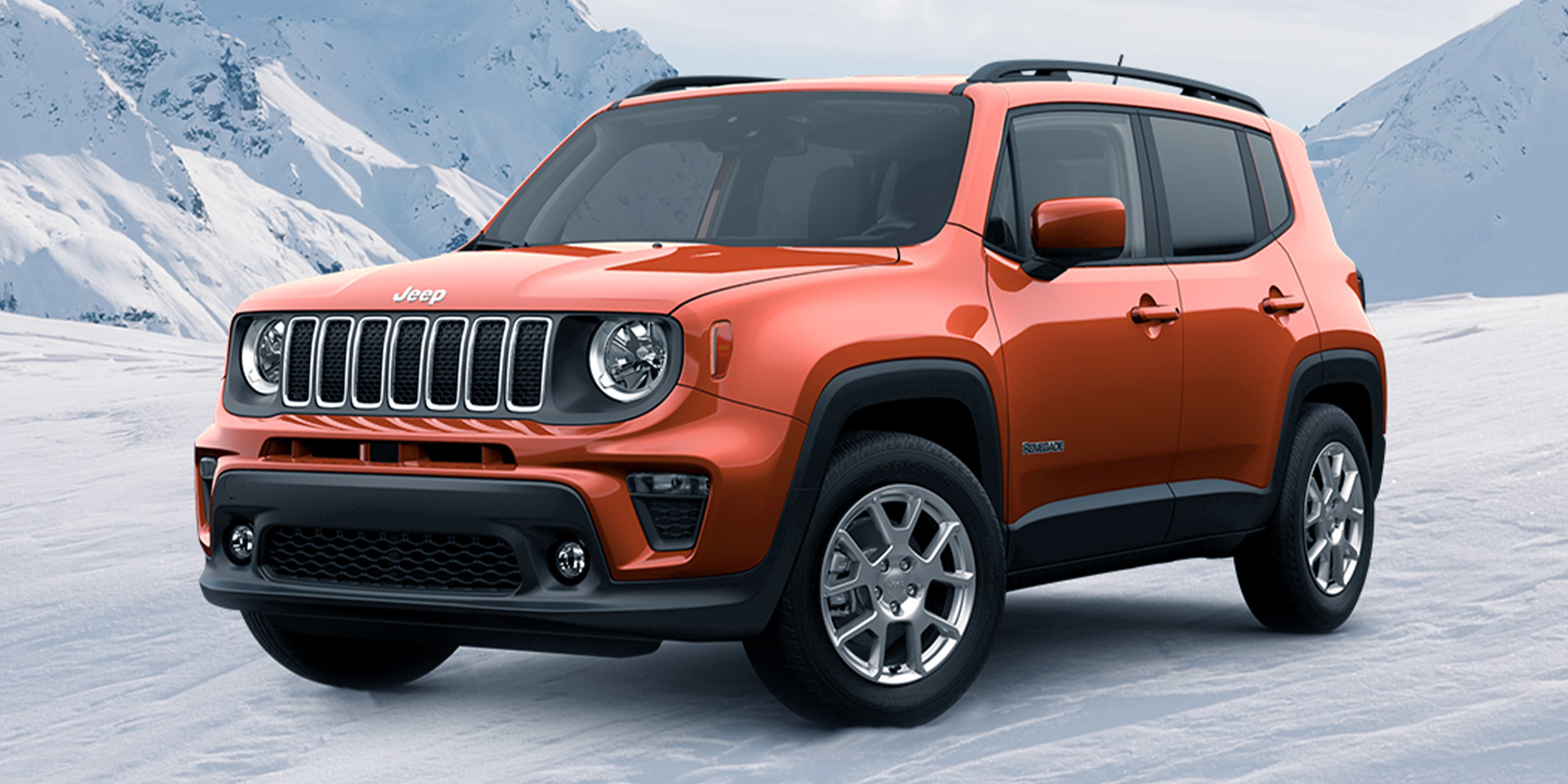 Renegade Latitude in Omaha Orange parked on snow covered mountain in the distance.