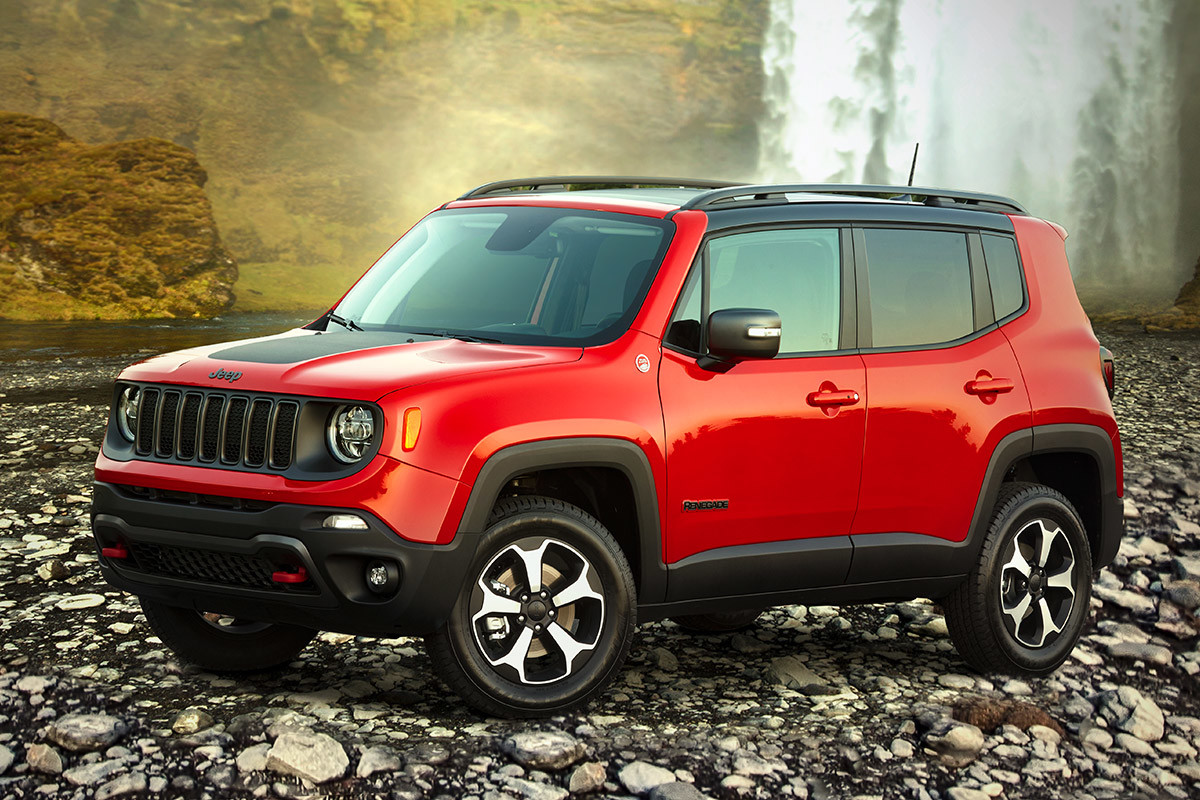 Jeep® Renegade rouge garé sur un chemin rocheux près d’une chute d’eau.