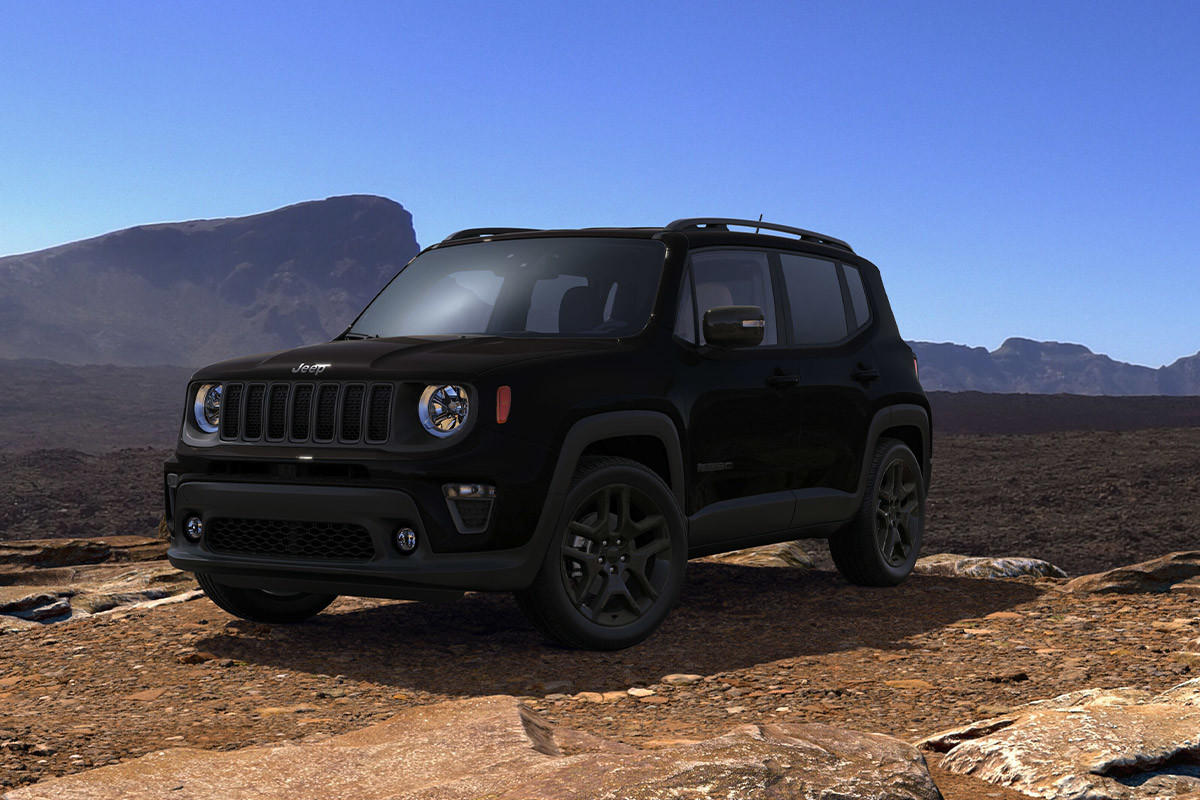 Jeep Renegade parked in a desert landscape with rocky mountains in the background.