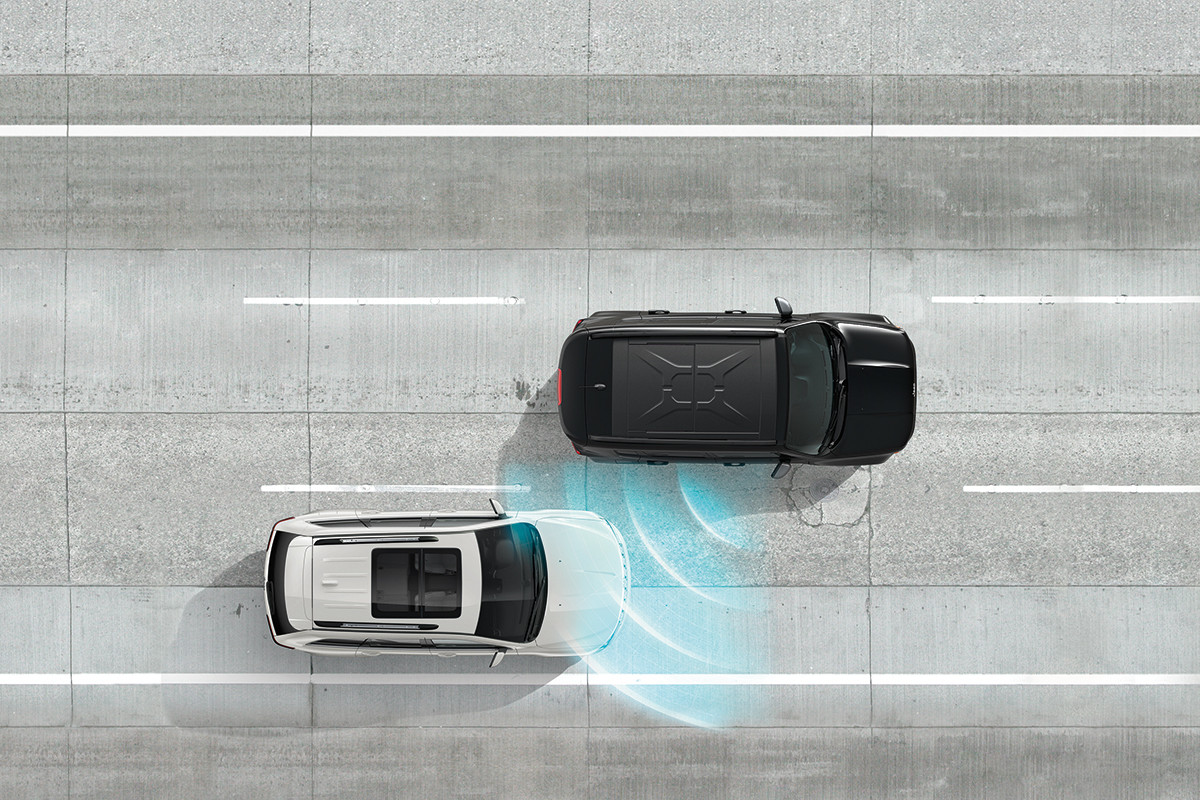 A black and white 2022 Jeep Renegade demonstrating the blind-spot monitoring system feature.