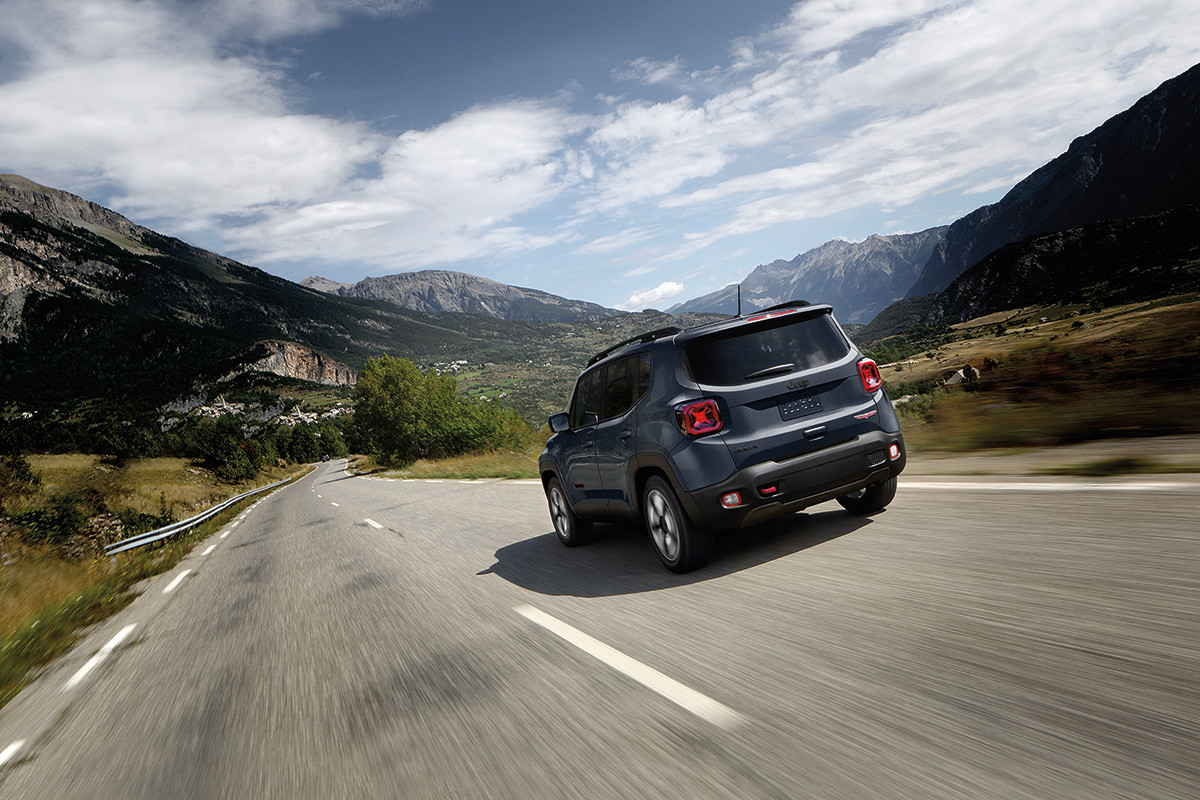 A dark grey 2022 Jeep Renegade driving down a mountain road.