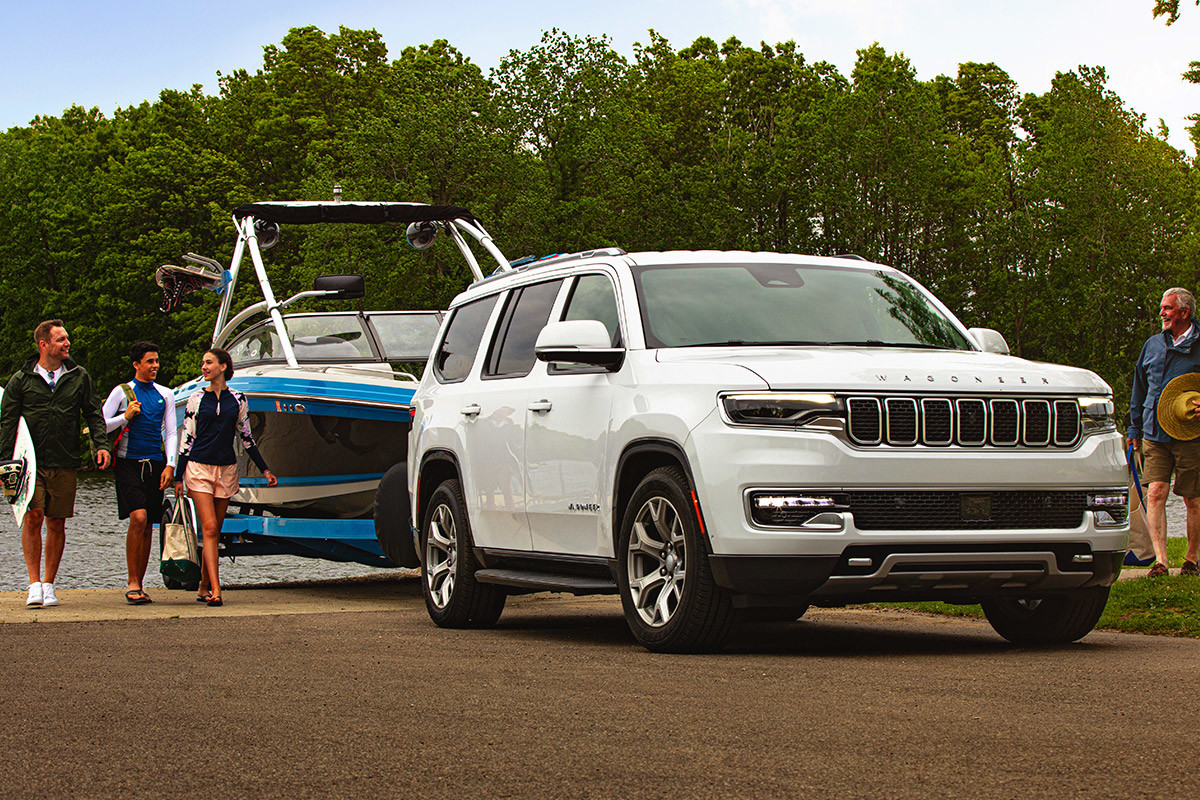 A white 2022 Wagoneer towing a boat out of the water.