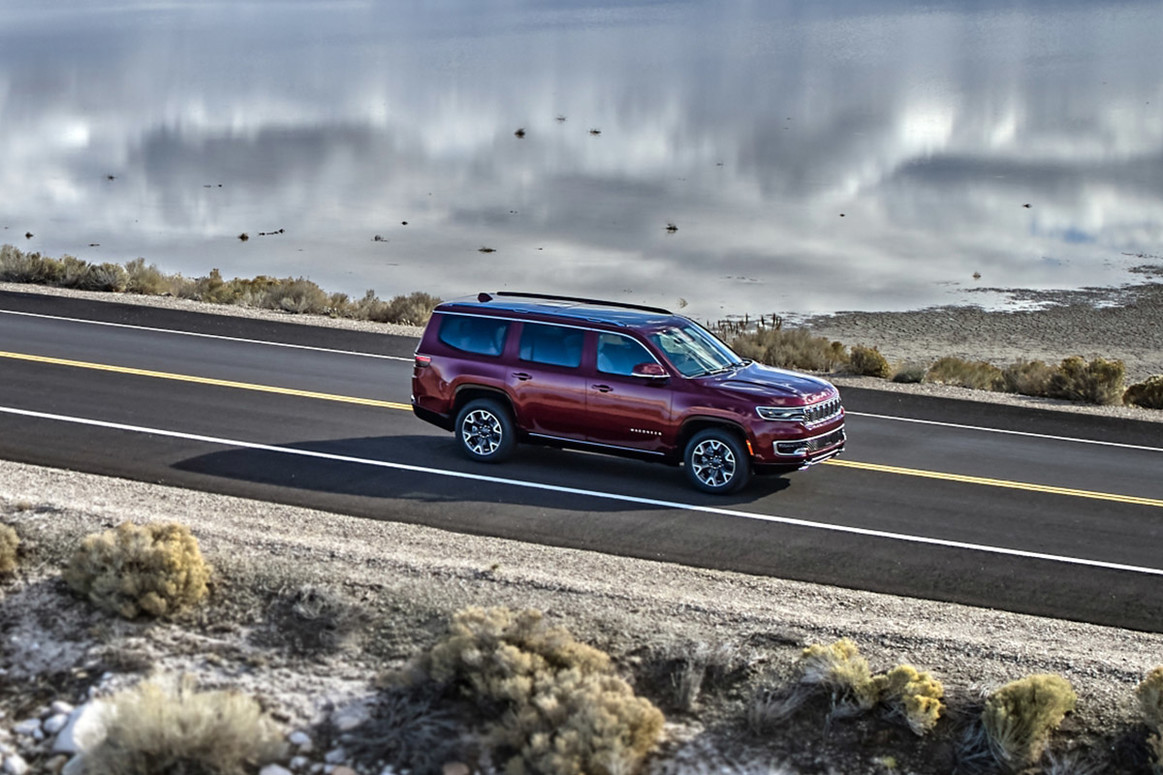 Un Wagoneer rouge 2022 circulant sur une route ouverte près de l’eau.