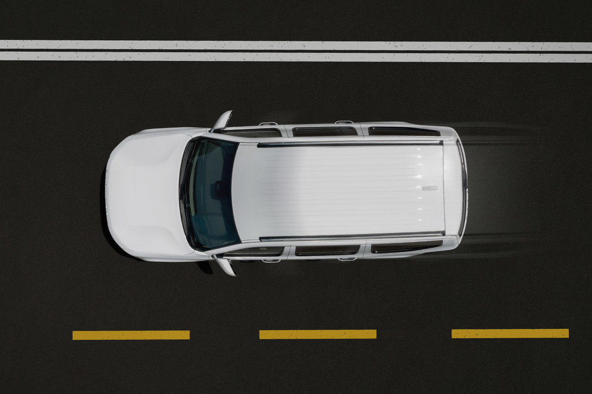 Vue à vol d’oiseau d’un Wagoneer blanc 2022 roulant sur une route.